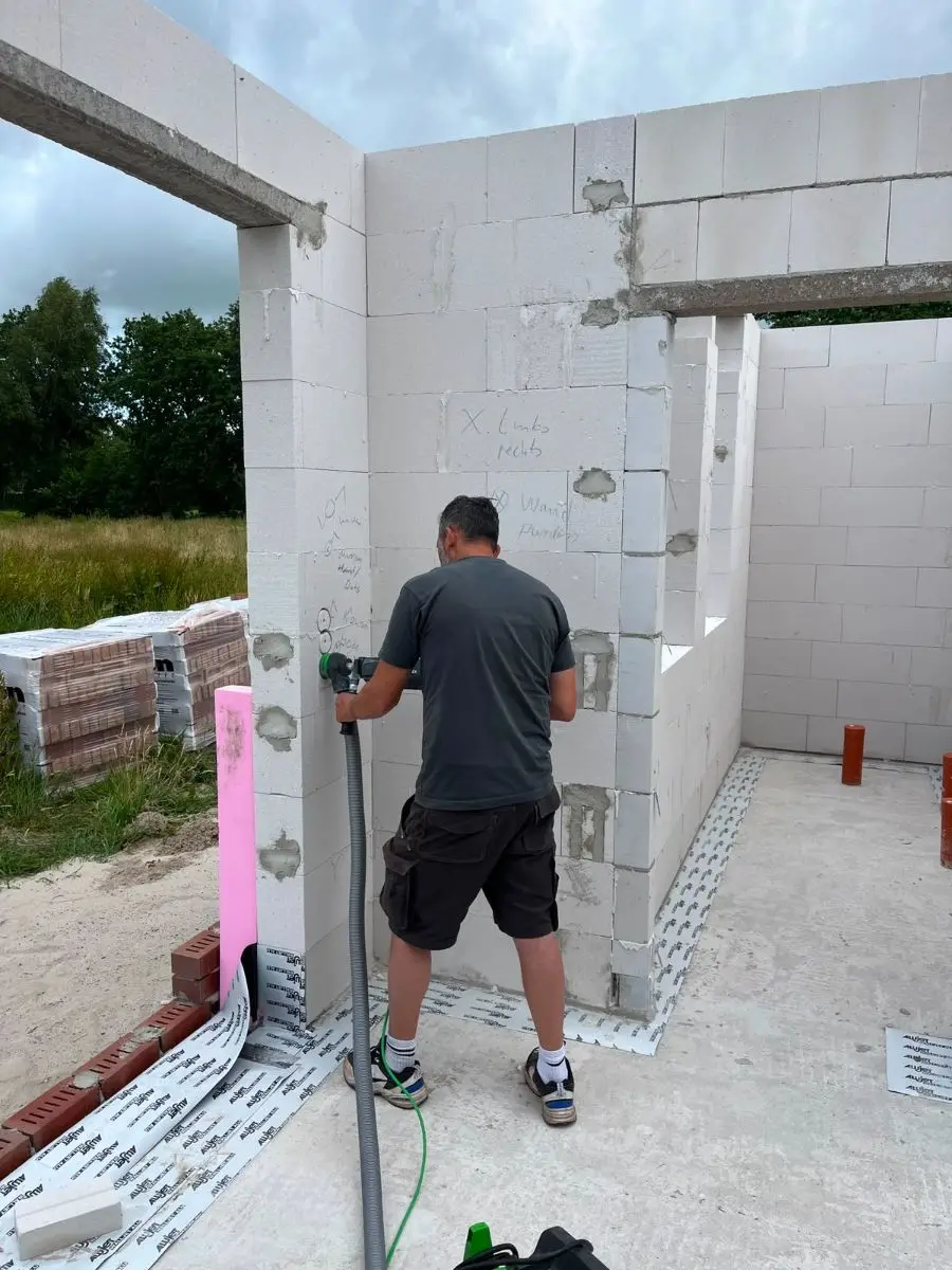 Leitungswege werden nach Plan an der Wand angezeichnet und gefräst